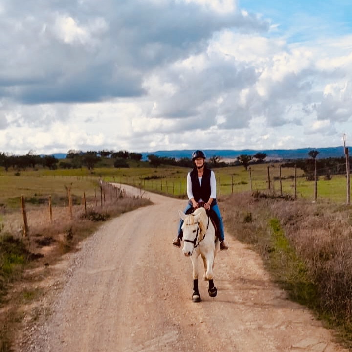 Woman on a white horse on a trail ride in the Alentejo, Portugal