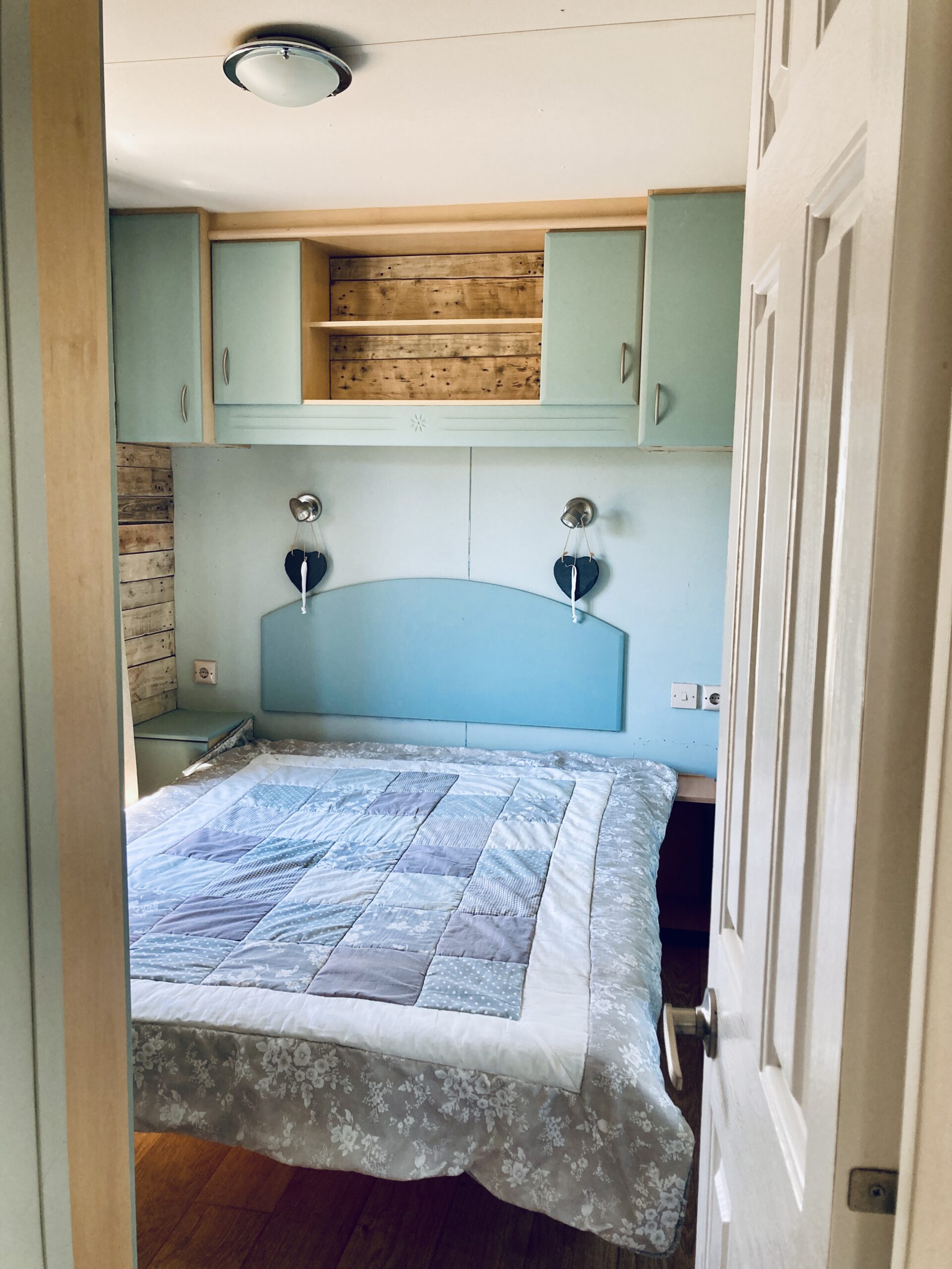 Look into the double bedroom with light blue wall of a holiday mobile cottage at Equus Ourique