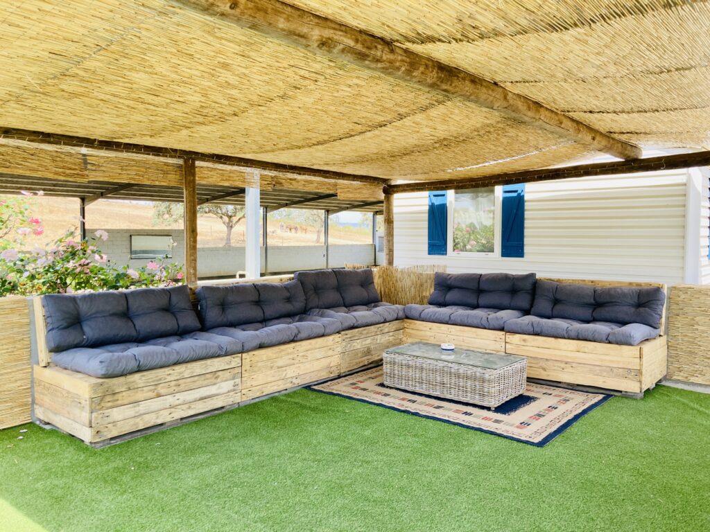 Wooden sofa bed on the covered outdoor lounge at Equus Ourique riding centre